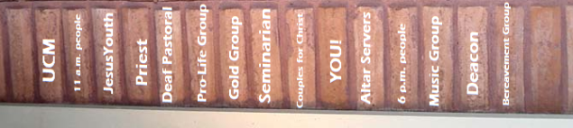 A row of vertical bricks with the names of parish activities on them